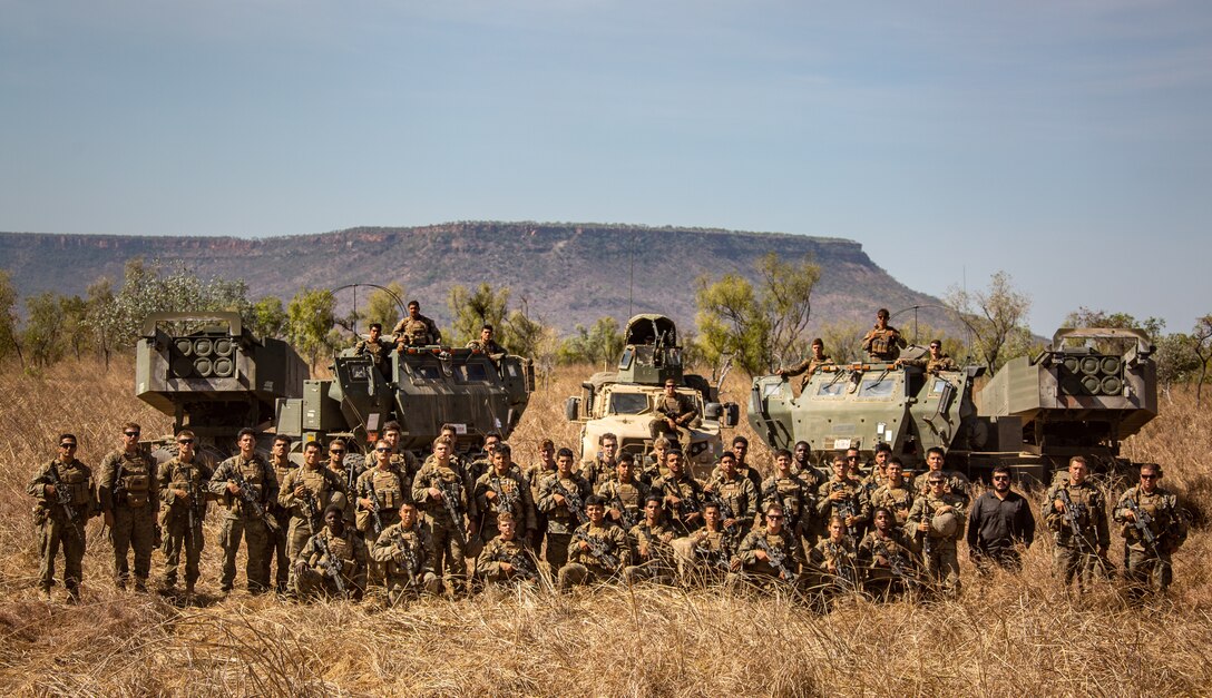 Marines pose for a field portrait with their deployable artillery rocket system.