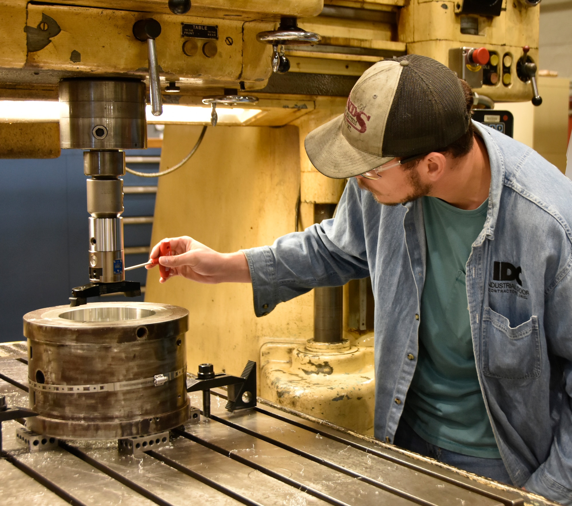 Peyton Teters, an aerospace precision machinist in the Arnold Engineering Development Complex Model and Machine Shop at Arnold Air Force Base, Tenn., attaches one of the new boring heads July 30, 2024, the Model Shop purchased using innovation grant funding received in 2024 through the AEDC Spark Tank program. The boring heads include technology that measures bored openings in equipment and features built-in digital readouts which allow machinists to quickly see whether a hole meets required specifications. (U.S. Air Force photo by Bradley Hicks) (This image was cropped for security purposes)