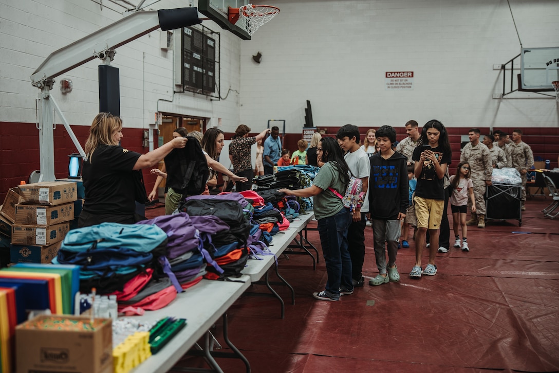 Marine Corps Air-Ground Combat Center community members receive free backpacks during The Combat Center Back-to-School Resource Fair at MCAGCC, Twentynine Palms, California, July 31, 2024. The Back-to-School Resource Fair gave MCAGCC community members the opportunity to receive free school supplies, connect with resources and speak with local school representatives. (U.S. Marine Corps photo by Lance Cpl. Richard PerezGarcia)