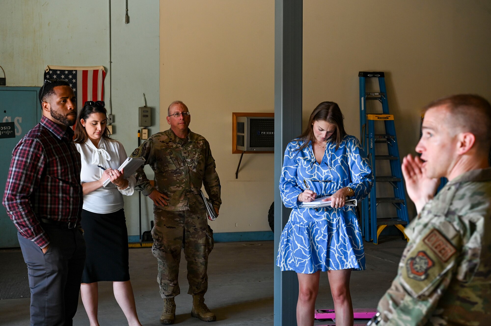 People listen to an Airman speak.