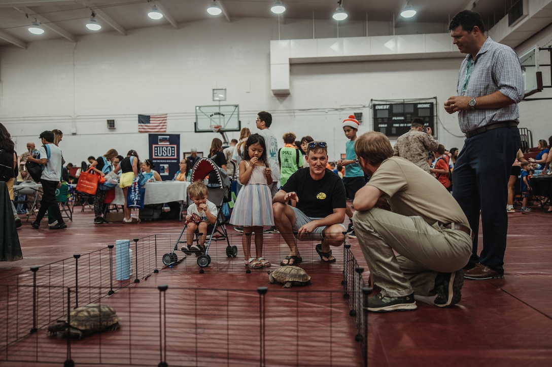 Marine Corps Air-Ground Combat Center community members visit Thelma and Louise, the Desert Tortoise ambassadors for MCAGCC, during The Combat Center Back-to-School Resource Fair at MCAGCC, Twentynine Palms, California, July 31, 2024. The Back-to-School Resource Fair gave MCAGCC community members the opportunity to receive free school supplies, connect with resources and speak with local school representatives. (U.S. Marine Corps photo by Lance Cpl. Richard PerezGarcia)