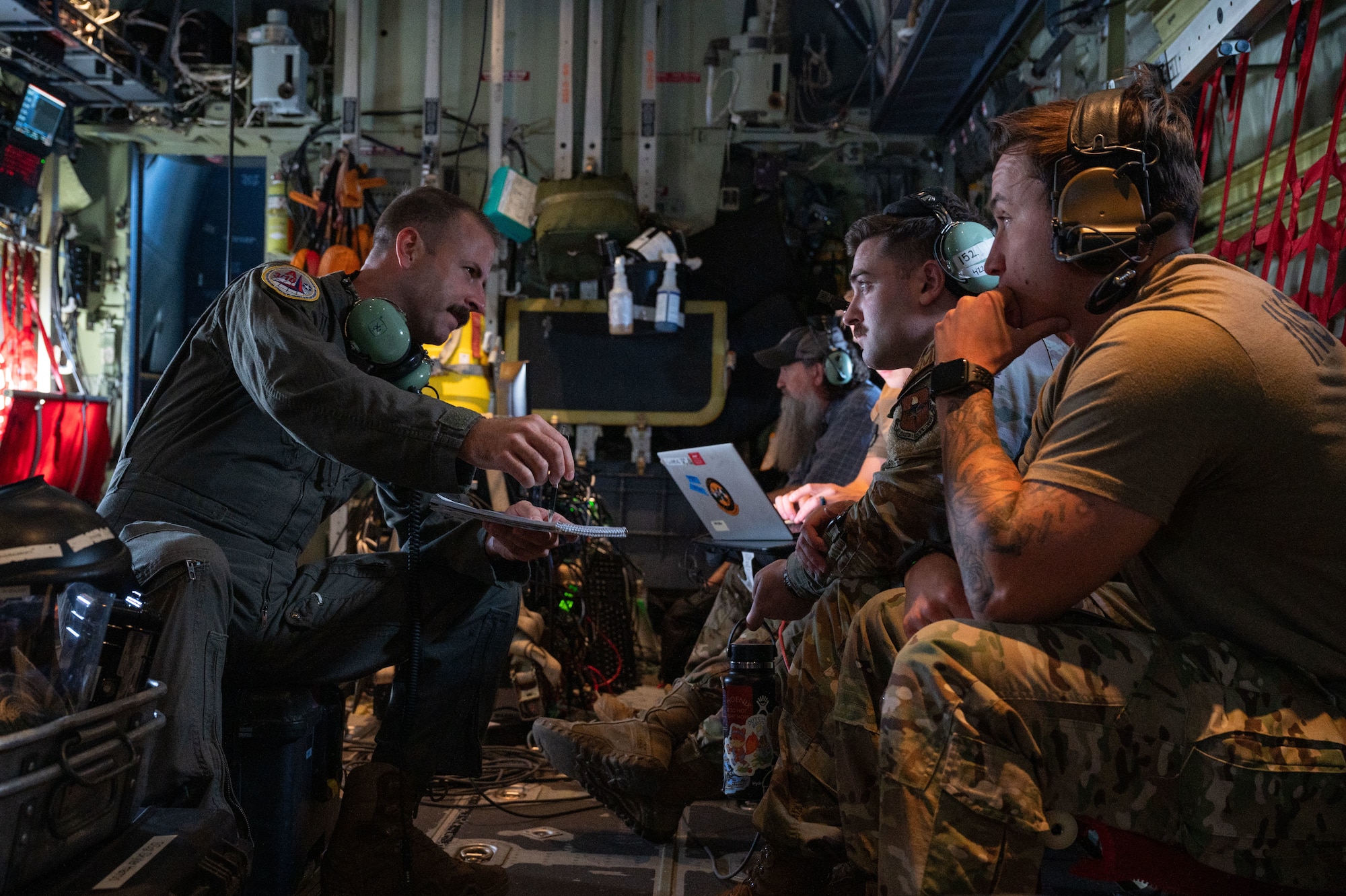 U.S. Air Force Master Sgt. Kyle Bone, Mission System Operator command manager, assigned to Air Mobility Command Headquarters, Scott Air Force Base (AFB), discusses command and control tactics, training and procedures with Air Battle Managers and Weapons Directors during Bamboo Eagle 24-3 at Nellis AFB, Nevada, Aug. 6, 2024. Airmen on this aircraft provided Red Air C2 operations during Bamboo Eagle 24-3. (U.S. Air Force photo by Senior Airman Josey Blades)