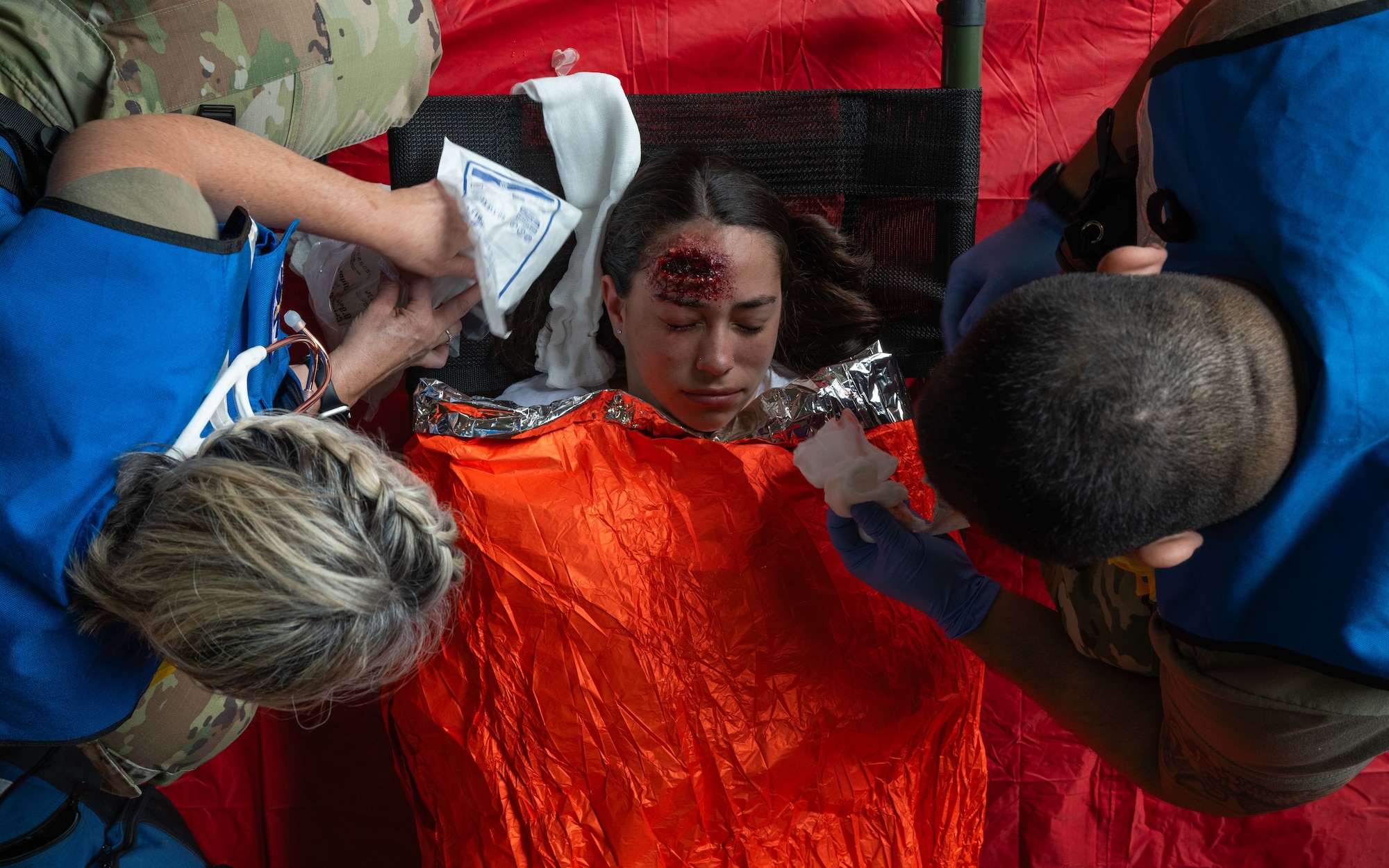 Airmen assigned to the 5th Medical Group provide medical treatment to a simulated casualty during a major accident response exercise (MARE) at Minot Air Force Base, North Dakota, Aug. 21, 2024. The realistic training opportunities provided by MAREs enhance readiness for first responders in the event of a real-world incident. (U.S. Air Force photo by Senior Airman Kyle Wilson)
