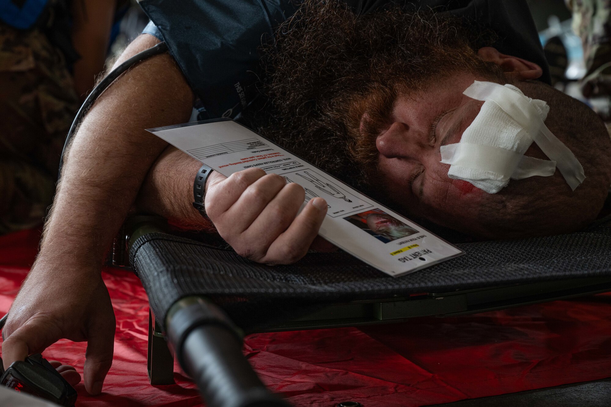 A simulated casualty lies on a stretcher after receiving medical treatment during a major accident response exercise (MARE) at Minot Air Force Base, North Dakota, Aug. 21, 2024. The MARE challenged Airmen to respond to a simulated helicopter crash during an airshow with attendees being injured as a result of the crash. (U.S. Air Force photo by Senior Airman Kyle Wilson)