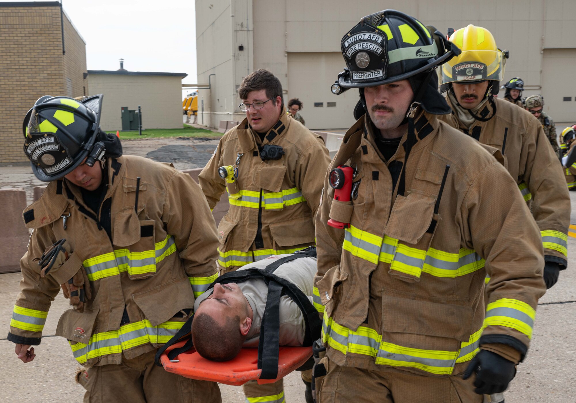 Firefighters assigned to the 5th Civil Engineer Squadron transport a simulated casualty during a major accident response exercise (MARE) at Minot Air Force Base, North Dakota, Aug. 21, 2024. MAREs allow first responders to continuously refine practices and procedures to enhance readiness in the event of a real-world incident. (U.S. Air Force photo by Senior Airman Kyle Wilson)