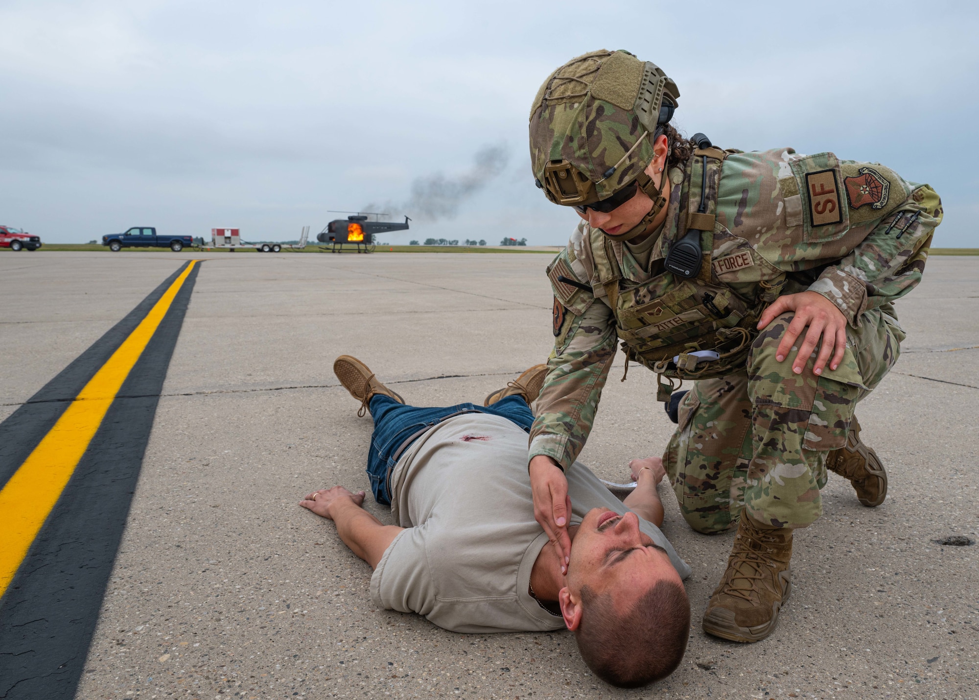 U.S. Air Force Senior Airman Payton Zittel, 5th Security Forces Squadron defender, checks a simulated casualty’s pulse during a major accident response exercise (MARE) at Minot Air Force Base, North Dakota, Aug. 21, 2024. The MARE challenged Airmen to respond to a simulated helicopter crash during an airshow with attendees being injured as a result of the crash. (U.S. Air Force photo by Senior Airman Kyle Wilson)