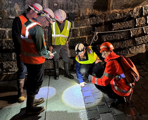 The group observes the transition between the granite and basalt at the Pfaffensprung sediment bypass tunnel. Researchers at the Swiss research university used test sections to observe different materials in the same environment and compare their performance in a real-world setting. (Photo by Carly Lynch, USACE – Alaska District)