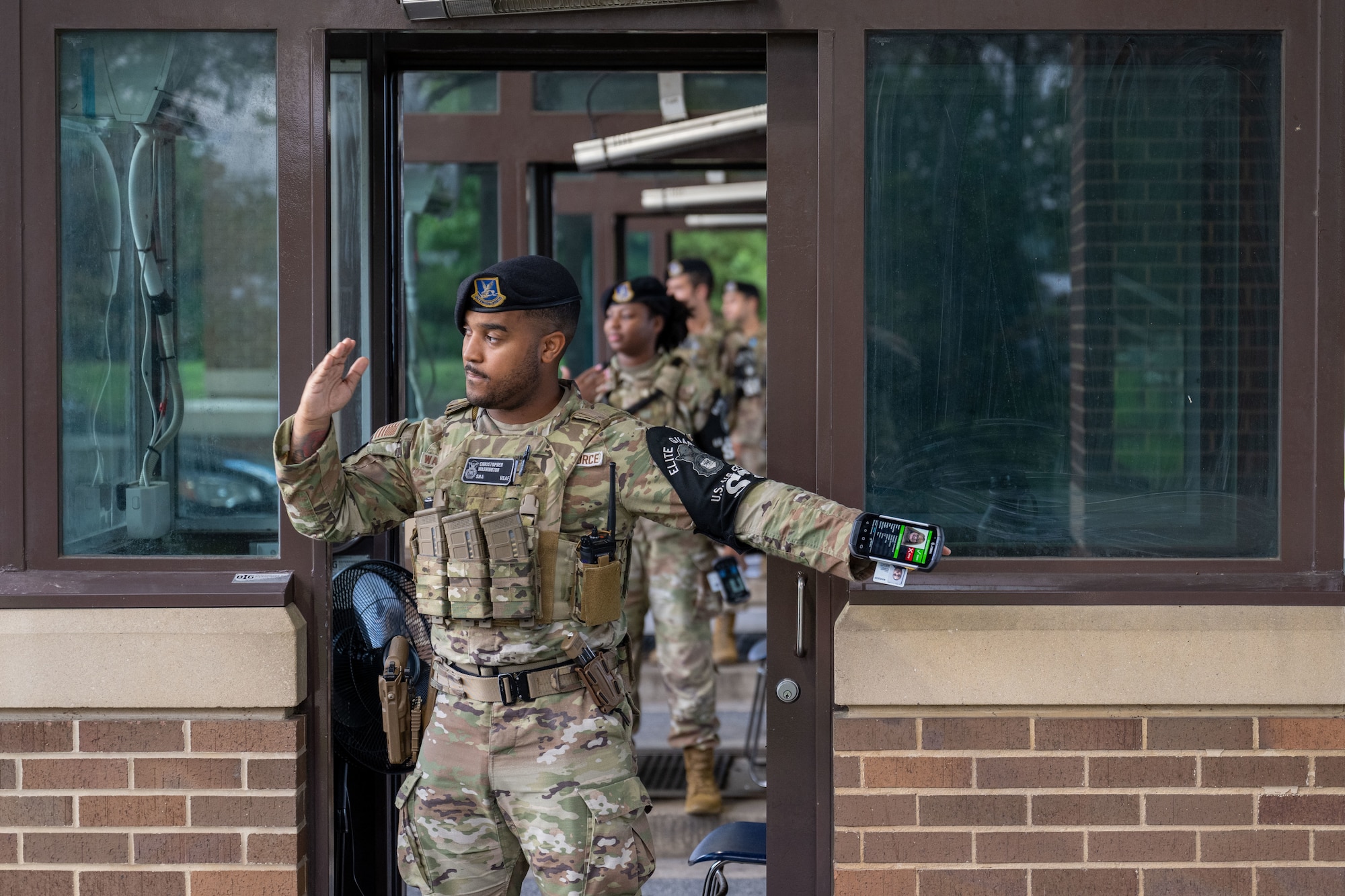 Airman waves on traffic at the gate to Joint Base Andrews.