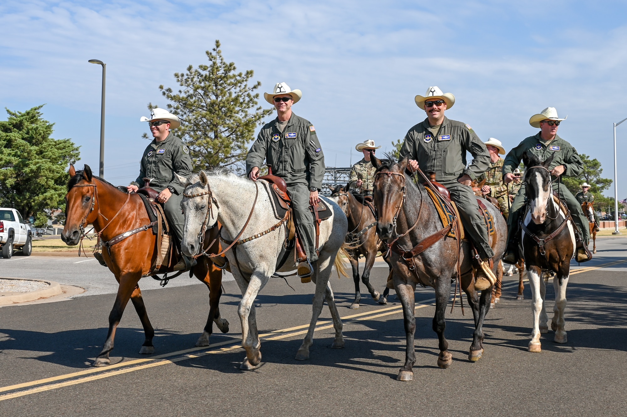 The 97th Air Mobility Wing command team leads a herd of longhorns through Altus Air Force Base, Oklahoma, during the 26th Annual Cattle Drive, Aug. 22, 2024. The cattle are guided approximately three and a half miles around the base, where Airmen and families are able to watch the longhorn cattle and horses. (U.S. Air Force photo by Senior Airman Kari Degraffenreed)