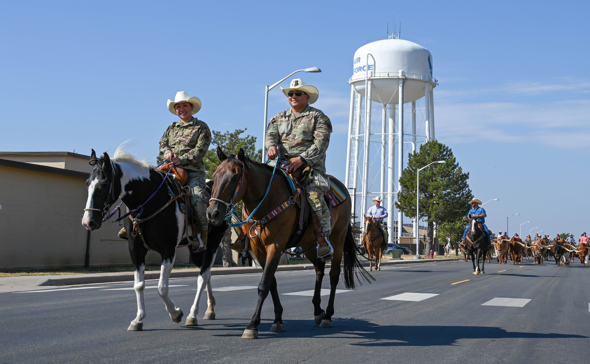 U.S. Air Force Senior Master Sgt. Davann Irons, left, 97th Medical Group senior enlisted leader, rides with Senior Master Sgt. Daniel Maruffo, 97th Air Mobility Wing senior enlisted leader, during the 26th Annual Cattle Drive at Altus Air Force Base, Oklahoma, Aug. 22, 2024. The cattle drive is conducted in the spirit of the ‘Great Western Cattle Trail,’ which started near Kerrville, Texas, and went north all the way to Canada. (U.S. Air Force photo by Senior Airman Trenton Jancze)