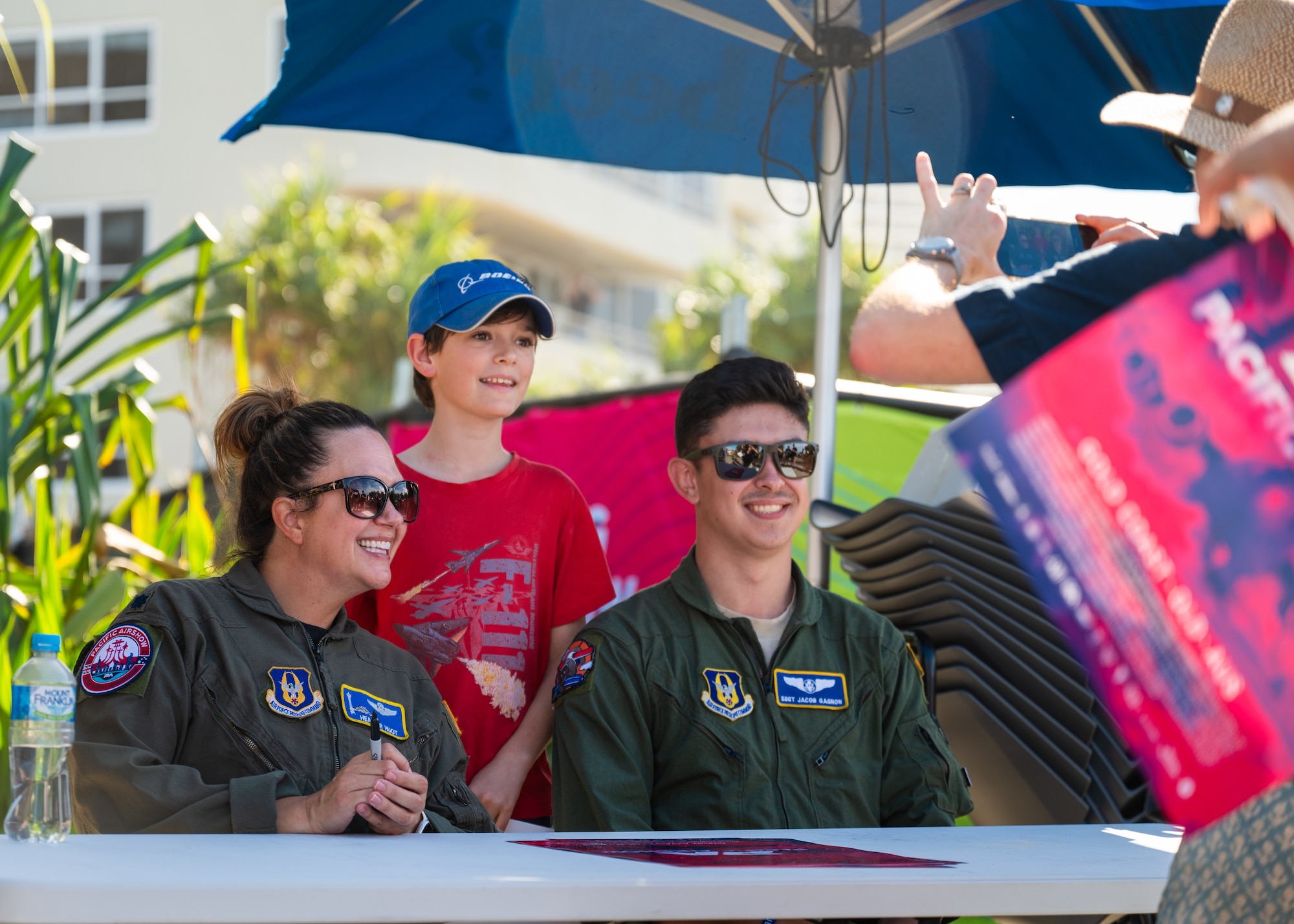 U.S. Air Force Lt. Col. Heather Huot, 313th Airlift Squadron pilot (left), and Staff Sgt. Jacob Gagnon, 728th Airlift Squadron loadmaster (right), pose for a photo with a fan during the Pacific Airshow Gold Coast in Gold Coast, Australia, on Aug. 16th, 2024.