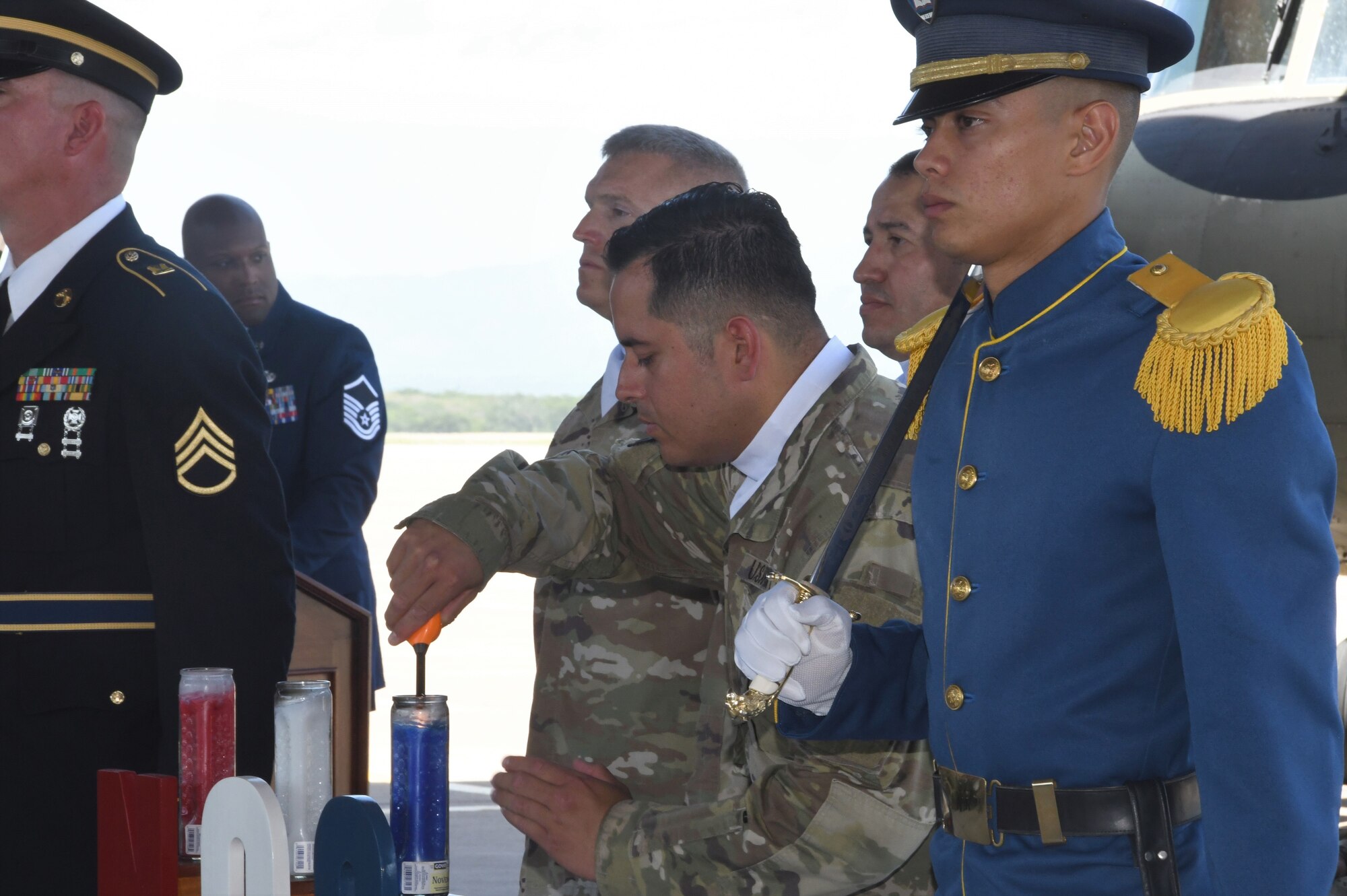 A photo of a service member lighting a candle.