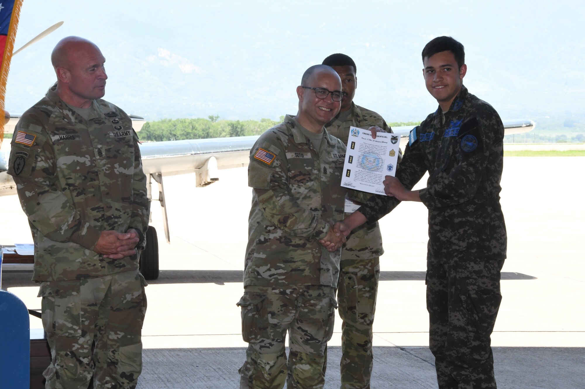 A photo of service members with a certificate.