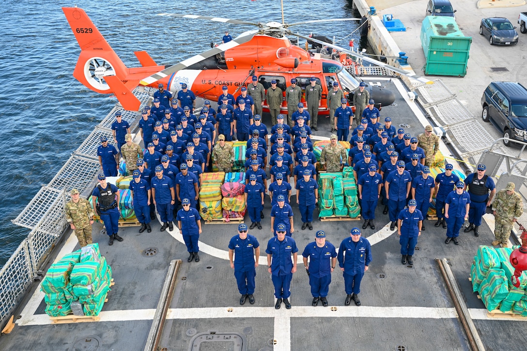 The crew of Coast Guard Cutter Escanaba pose with more than 3,400 pounds of cocaine and 4,410 pounds of marijuana with a combined assessed street value of approximately $50 million in Port Everglades, Florida, Aug. 23, 2024. Escanaba's crew worked alongside an embarked Coast Guard Helicopter Interdiction Tactical Squadron aircrew, Law Enforcement Detachment 107 from Coast Guard Tactical Law Enforcement Team Pacific, and interagency and international partners to interdict illicit narcotics in the international waters of the Eastern Pacific Ocean. (U.S. Coast Guard photo by Petty Officer 3rd Class Eric Rodriguez)