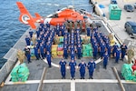 The crew of Coast Guard Cutter Escanaba pose with more than 3,400 pounds of cocaine and 4,410 pounds of marijuana with a combined assessed street value of approximately $50 million in Port Everglades, Florida, Aug. 23, 2024. Escanaba's crew worked alongside an embarked Coast Guard Helicopter Interdiction Tactical Squadron aircrew, Law Enforcement Detachment 107 from Coast Guard Tactical Law Enforcement Team Pacific, and interagency and international partners to interdict illicit narcotics in the international waters of the Eastern Pacific Ocean. (U.S. Coast Guard photo by Petty Officer 3rd Class Eric Rodriguez)