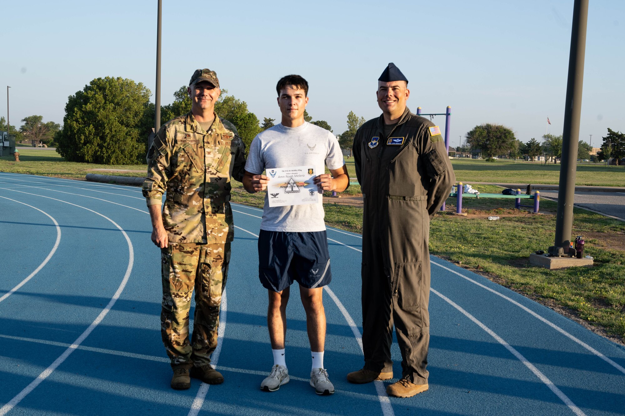 U.S. Air Force Airman 1st Class Noah Melero, 97th Civil Engineer Squadron electrical systems apprentice, center, is awarded the May Airman of the Month certificate by Col. Jeff Marshall, 97th Air Mobility Wing (AMW) commander, left, and Chief Master Sgt. Justin Brundage, 97th AMW command chief, right, at Altus Air Force Base Oklahoma, June 14, 2024. Some things Melero did to win airman of the month were install 12 new LED light fixtures for an outdoor recreational area, assist fire alarm system technicians in conducting preventative maintenance, and plan a Mother’s Day event for his co-workers. (U.S. Air Force photo by Senior Airman Miyah Gray)