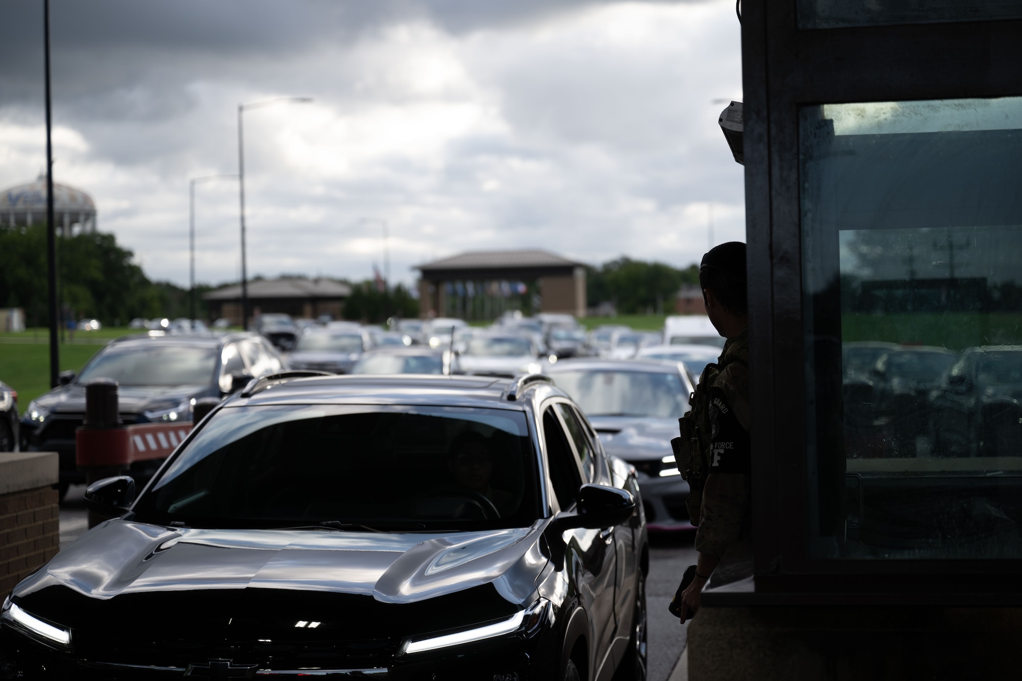 An airman looks on at the line of cars entering Joint Base Andrews.