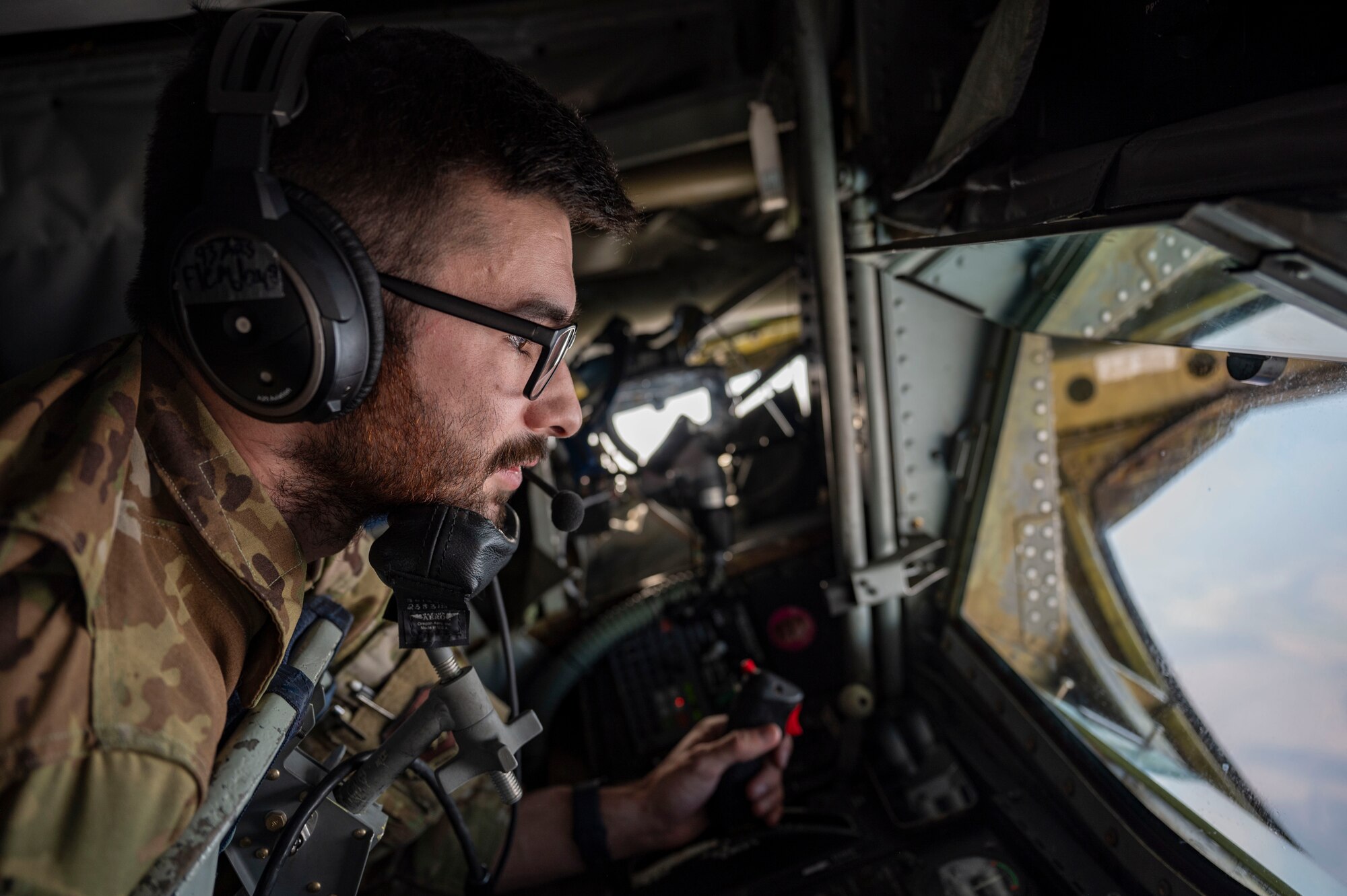 An in-flight refueling specialist lays in the boom pod.