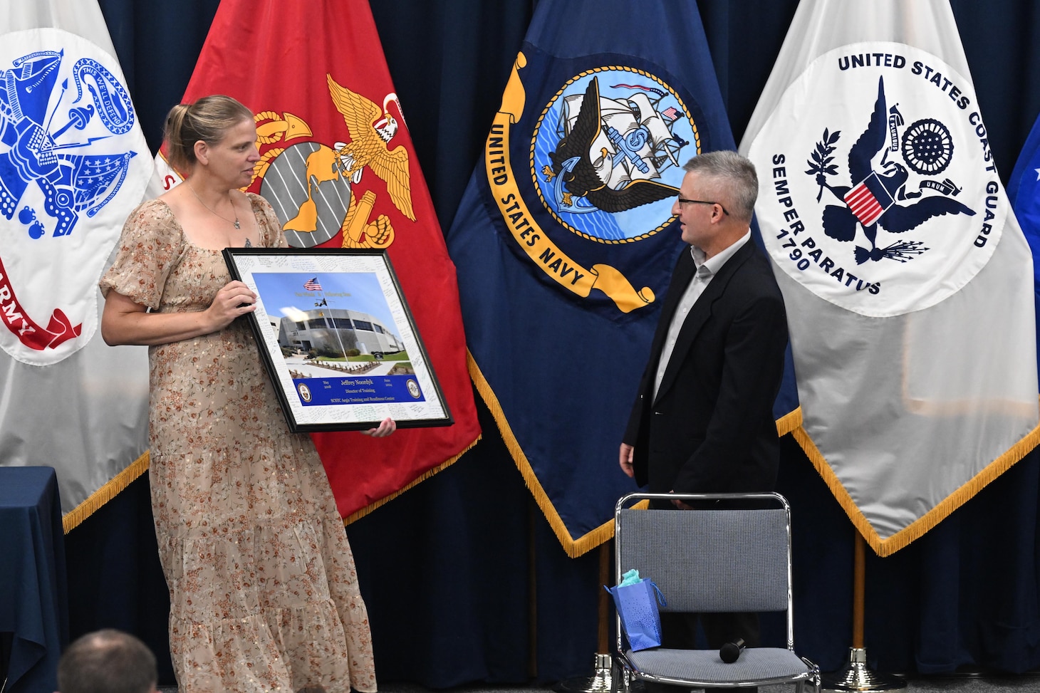 DAHLGREN, Va. (July 08, 2024) Ms. Amanda Blackman, director of Training and Facilities Readiness for Surface Combat Systems Training Command AEGIS Training and Readiness Center (SCSTC ATRC) presents Mr. Jeff Noordyk, SCSTC ATRC’s director of Training, a photo of the schoolhouse with numerous signatures from Noordyk’s coworkers during a farewell event onboard Naval Support Facility Dahlgren, Virginia.  (U.S. Navy photo by Michael Bova)