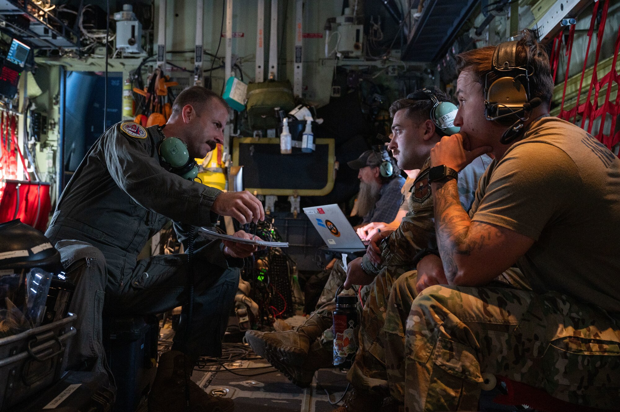 U.S. Air Force Master Sgt. Kyle Bone, Mission System Operator command manager, assigned to Air Mobility Command Headquarters, Scott Air Force Base (AFB), discusses command and control tactics, training and procedures with Air Battle Managers and Weapons Directors during Bamboo Eagle 24-3 at Nellis AFB, Nevada, Aug. 6, 2024. Airmen on this aircraft provided Red Air C2 operations during Bamboo Eagle 24-3. (U.S. Air Force photo by Senior Airman Josey Blades)