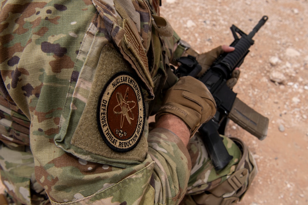 Airman kneels down with weapon ready during training on the rifle range