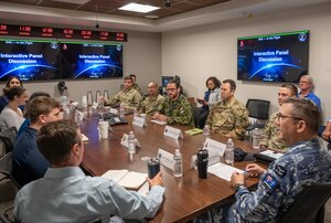 Military members brief members of the  Congressional Senior Staff Fellowship program in a conference room.