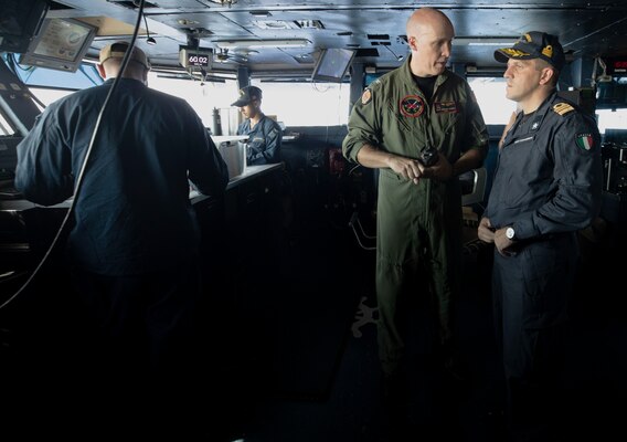 Capt. Thomas Lovett, Chief of Staff of Carrier Strike Group Eight (CSG 8), has a discussion with Capt. Marco Felici