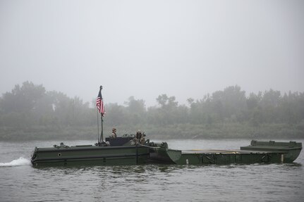 Soldiers with the 957th Multi-role Bridge Company, North Dakota Army National Guard, use an M30 Bridge Erection Boat to maneuver a bridge bay across the Missouri River during a wet gap crossing training exercise near Kimball Bottoms, North Dakota, Aug. 17, 2024. The exercise also included military police, air defense artillery and aviation units with the North Dakota Army Guard.