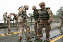 Soldiers with the 957th Multi-role Bridge Company, North Dakota Army National Guard, use T-bars to secure two floating bays of an Improved Ribbon Bridge during a wet gap crossing training exercise on the Missouri River near Kimball Bottoms, North Dakota, Aug. 17, 2024. The exercise tested the unit’s ability to establish vital infrastructure in domestic and combat scenarios.