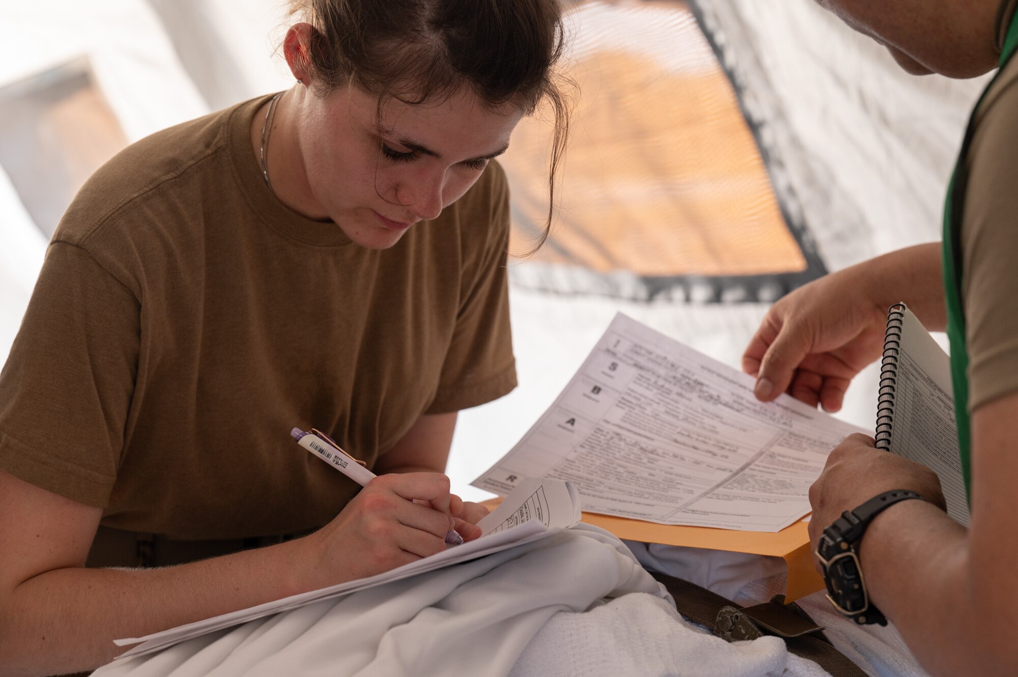 Airman Carrier Kloe-Leah, 927th ASTS aerospace medical service specialist completes patient paperwork during Operation Blue Horizon on MacDill AFB, June 6, 2024. Blue Horizon was a Navy Reserve-led joint exercise giving total-force medics, doctors, nurses and other military healthcare professionals the chance to experience the full depth of tactical combat casualty care and aeromedical evacuation. (U.S. Air Force photo by Tech. Sgt. Bradley Tipton)