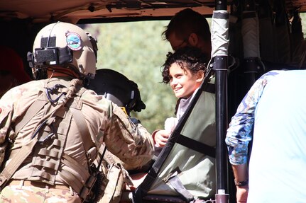 An Arizona Army National Guard Soldier helps a child into a UH-60 Black Hawk helicopter Aug. 24, 2024, at the Havasupai Indian Reservation. More than 100 people were evacuated out of the canyon after flood waters impacted the Havasupai community and tourists visiting Havasupai Falls.