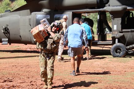 An Arizona National Guard Soldier unloads food from a UH-60 Black Hawk during one of three resupply dropoffs Aug. 24, 2024, on the Havasupai Indian Reservation.