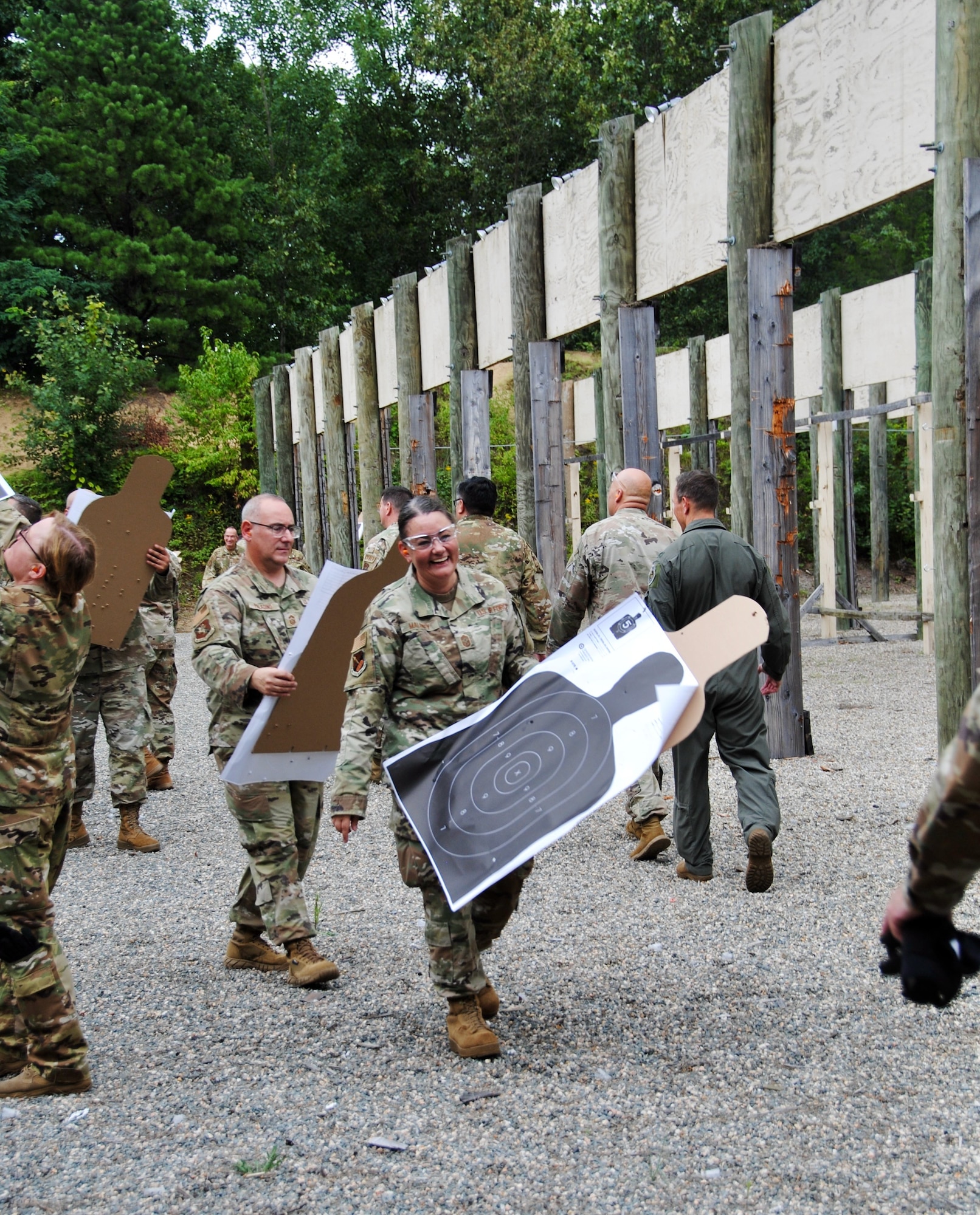 Citizen Airmen senior leaders carry paper-and-cardboard targets silhouettes at the outdoor small arms training range Aug. 6. An Excellence in Competition round of firing with the new Sig Sauer M-18 pistol was part of a two-day warfighting conference was hosted by Westover Air Reserve Base and led by Lt. Gen. John Healy, Air Force Reserve Commander. The event centered on ensuring Citizen Airmen senior leaders are “Ready Now” and have the tools and equipment to transform for future threats to the nation’s defense.