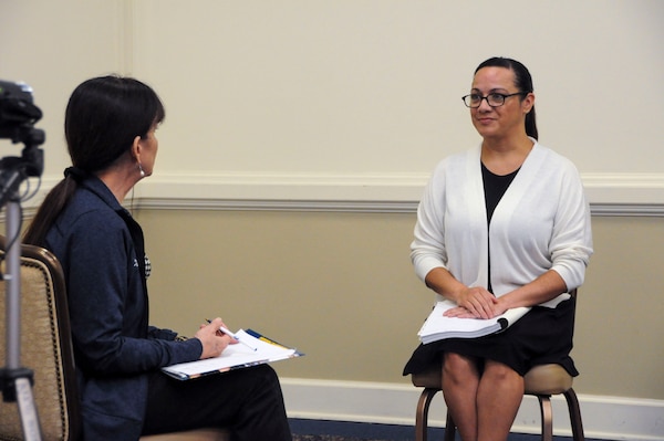 Sandy Martinez, a contractor with the environmental health directorate, at the Navy and Marine Corps Force Health Protection Command, interviews MSgt. Sara Moreno, a public health superintendent with the 633rd Operational Medical Readiness Squadron during a risk communication workshop Aug. 15, 2024, at the Rivers Edge Conference Center, on Naval Medical Center Portsmouth, Virginia. The risk communication workshop focused on how to plan and execute communications to internal and external stakeholders on any public health issue that impacts their mission. Stationary and roving interviews were conducted to allow the students to apply some of the speaking techniques they have learned from the workshop. (Navy photo by Desmond Martin)