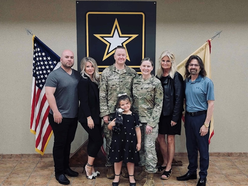 Capt. Mckenzie N. Elliott, commander, Headquarters and Headquarters Company, Special Troops Battalion, 1st Theater Sustainment Command; her husband, Capt. Andy Elliott and family members stand together at her Assumption of Command, April 19, 2024, Fort Knox, Kentucky. Elliott is a member of the small, tight-knit Explosive Ordnance community.