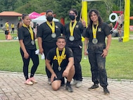 Five U.S. Army Soldiers pose together with their medals for winning an event