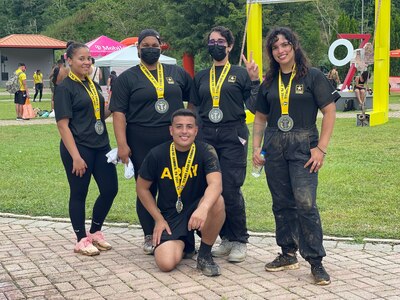 Five U.S. Army Soldiers pose together with their medals for winning an event