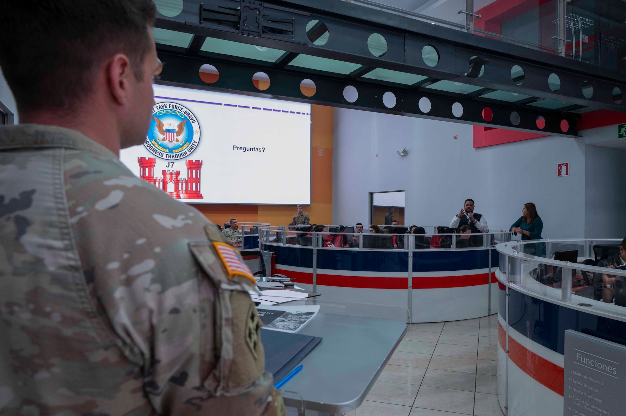 A photo of a Solider looking at a person holding a microphone, asking a question.