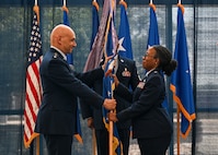 U.S. Air Force Lt. Gen. Brian S. Robinson, Air Education and Training Command commander, passes the guidon to Brig. Gen. Gwendolyn A. Foster, 59th Medical Wing commander, at the 59th MDW change of command ceremony at Joint Base San Antonio, Tx., Aug. 23, 2024.