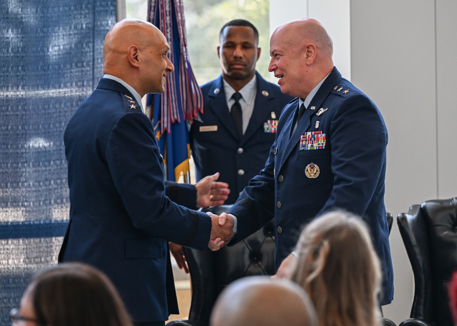 U.S. Air Force Lt. Gen. Brian S. Robinson, Air Education and Training Command commander, shakes hands with Maj. Ge. Thomas Harrell, Air Force Medical Command Medical Readiness-Alpha, at the 59th Medical Wing change of command ceremony Aug. 23, 2024.