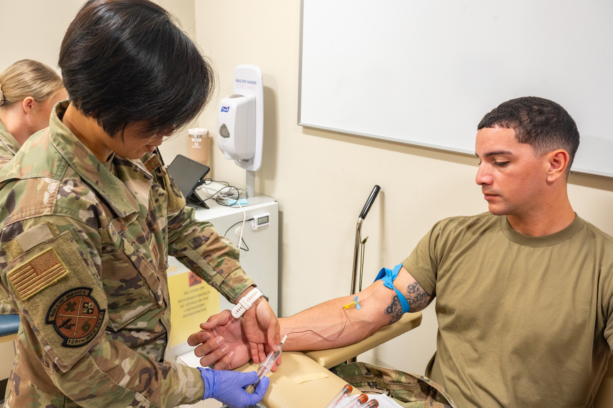 U.S. Air Force Capt. Chea Lim, clinical nurse, 125th Medical Group, Detachment 1, performs a blood draw during an exercise Aug. 9, 2024, at Muñiz Air National Guard Base, Carolina, Puerto Rico. The training exercise enhances air-load capabilities, refines pre- and post- deployment procedures, expands mission readiness in an unfamiliar environment, and fulfills Comprehensive Medical Readiness Plan requirements, including critical care, search and extraction, and Air Force Specialty Code proficiency training, while collaborating with the 156th Medical Group. The exercise also includes providing Individual Medical Readiness support for members of the 156th WG population. (U.S. Air National Guard photo by Senior Airman Jesse Hanson) (This photo has been altered for security purposes by blurring sensitive information.)