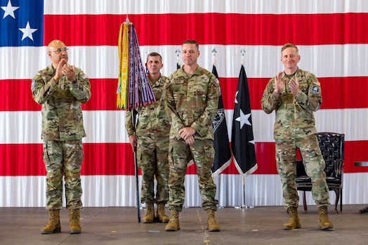  Lt. Gen. David N. Miller, Jr., Space Operations Command commander, left, and Col. Christopher Kennedy, Commander, Space Delta 6, right, clap after Col. Travis Prater, center, officially took command of Space Delta 6 - Space Access and Cyberspace Operations during a change of command ceremony.