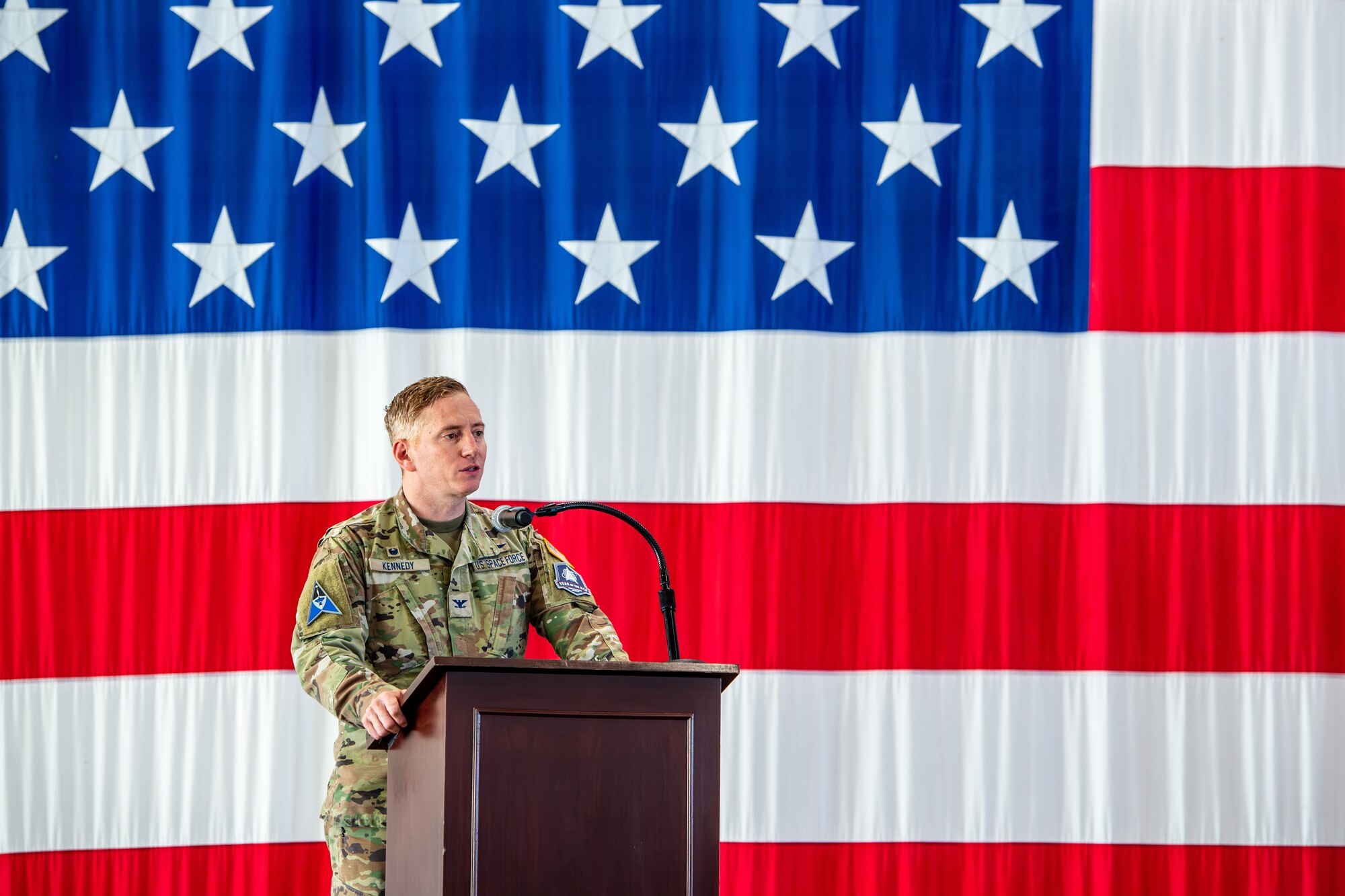 Col. Christopher Kennedy gives a speech on stage.
