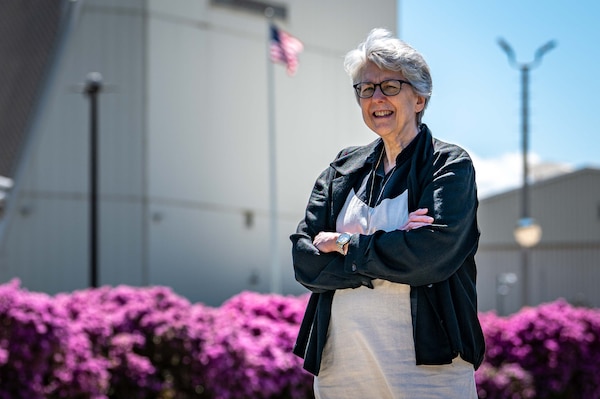 woman stands arms crossed in front of space force radar system.