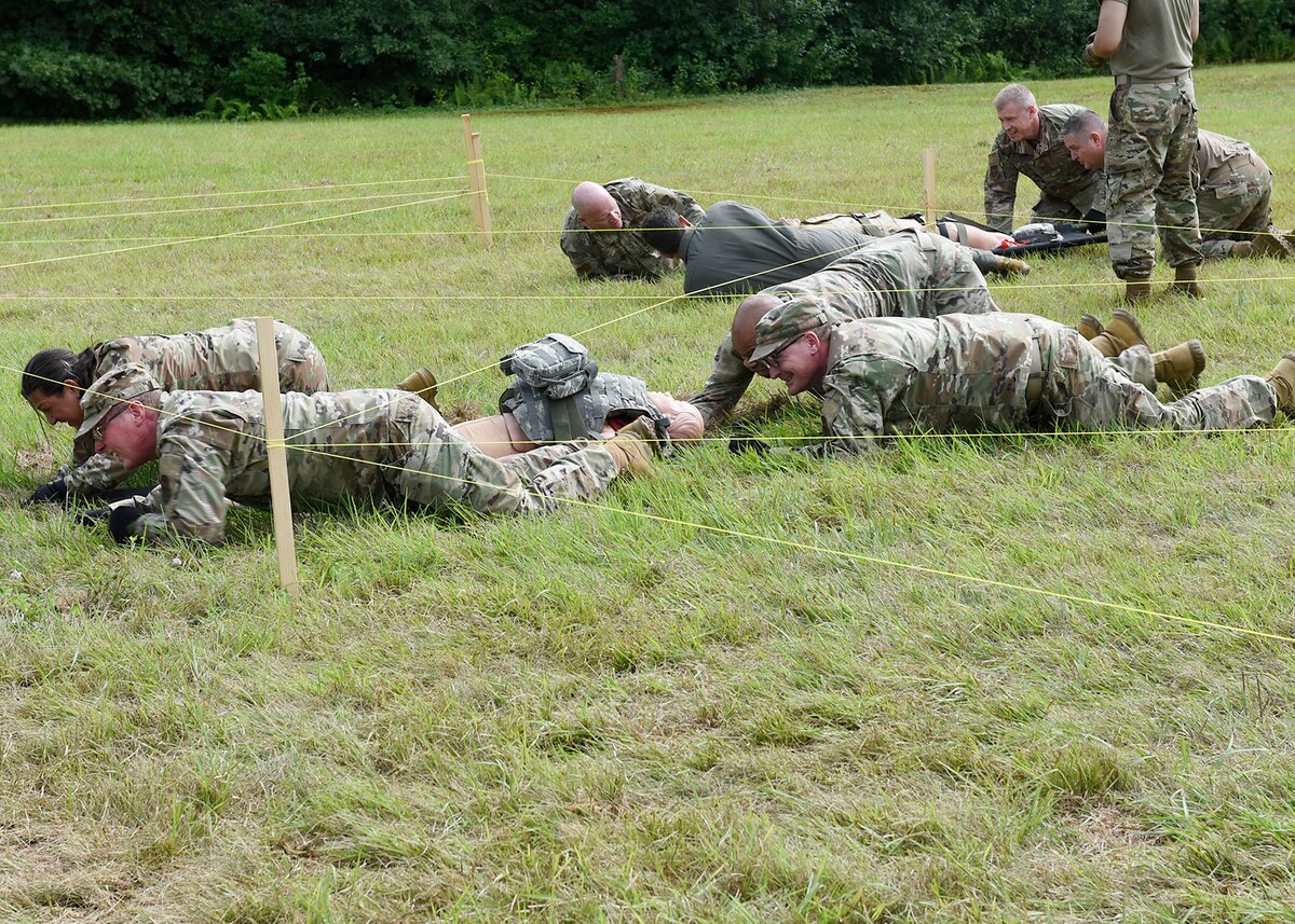 Four Citizen Airmen senior leaders low-crawl under simulated barbwire while transporting a litter patient during Tactical Combat Casualty Care training Aug. 6. The hands-on readiness training was part of the two-day warfighting conference was hosted by Westover Air Reserve Base and led by Lt. Gen. John Healy, Air Force Reserve Commander. The event centered on ensuring Citizen Airmen senior leaders are “Ready Now” and have the tools and equipment to transform for future threats to the nation’s defense.