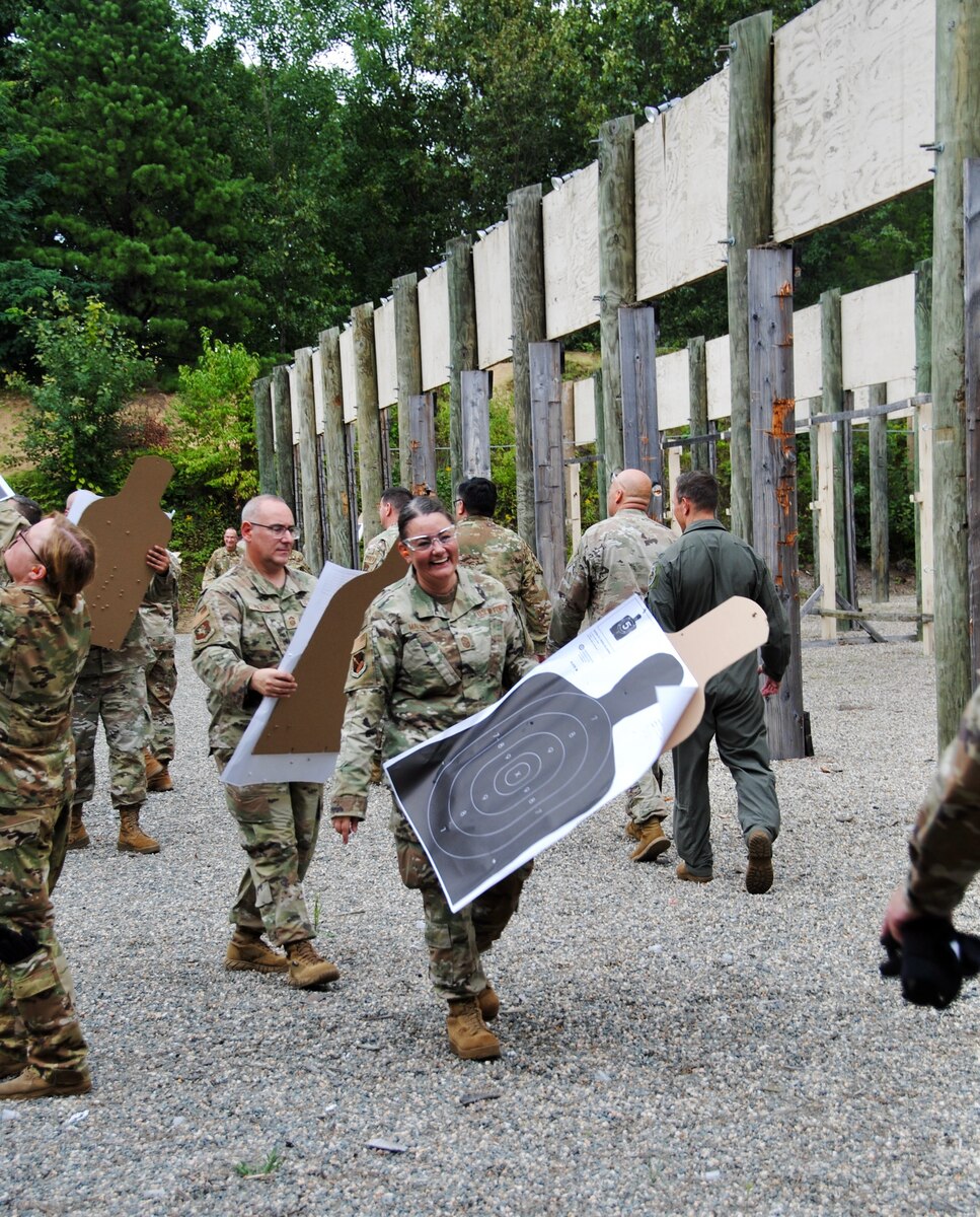 Citizen Airmen senior leaders carry paper-and-cardboard targets silhouettes at the outdoor small arms training range Aug. 6. An Excellence in Competition round of firing with the new Sig Sauer M-18 pistol was part of a two-day warfighting conference was hosted by Westover Air Reserve Base and led by Lt. Gen. John Healy, Air Force Reserve Commander. The event centered on ensuring Citizen Airmen senior leaders are “Ready Now” and have the tools and equipment to transform for future threats to the nation’s defense.
