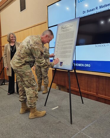 Col. Daniel Cornelius, 75th Air Base Wing commander, signs the Women’s Equality Day proclamation.