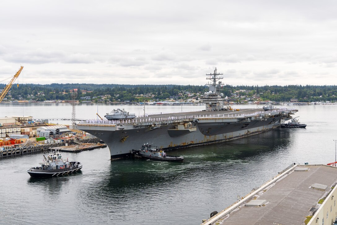 Sailors line the flight deck as USS Ronald Reagan (CVN 76) arrives at its new homeport on Naval Base Kitsap-Bremerton, Aug. 13, 2024. The Nimitz-class carrier will soon begin a scheduled Docking Planned Incremental Availability at Puget Sound Naval Shipyard & Intermediate Maintenance Facility in Bremerton, Washington. (U.S. Navy photo by Wendy Hallmark)