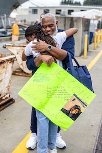 Anya Williams receives a hug from her father, James Whitney, after arriving at Naval Base Kitsap-Bremerton, Washington, aboard USS Ronald Reagan (CVN 76) Aug. 13, 2024. (U.S. Navy photo by Jeb Fach)