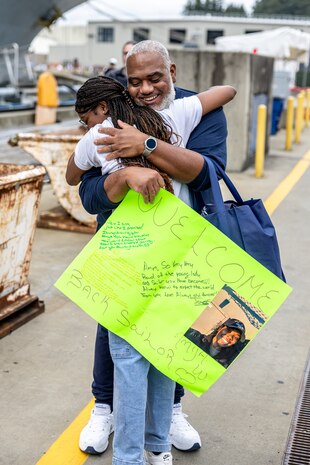 Anya Williams receives a hug from her father, James Whitney, after arriving at Naval Base Kitsap-Bremerton, Washington, aboard USS Ronald Reagan (CVN 76) Aug. 13, 2024. (U.S. Navy photo by Jeb Fach)